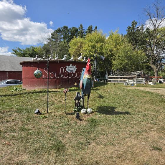 The red SoulSpace silo sign with a rooster sculpture out front