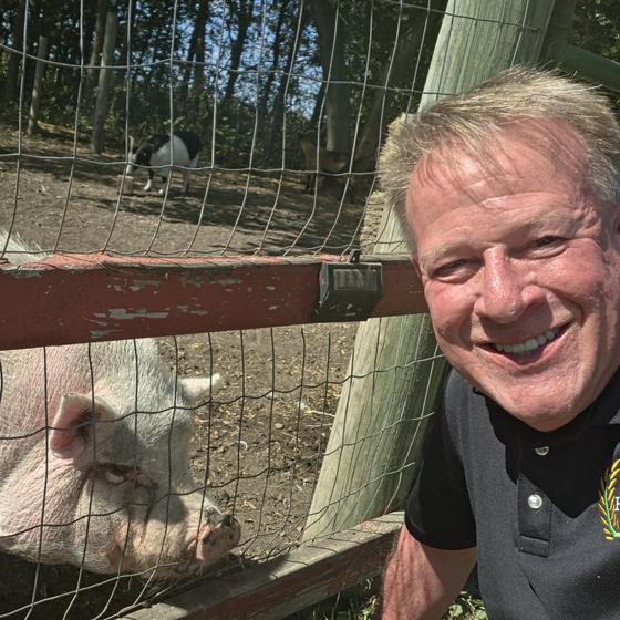 A Harvest Pack team member taking a selfie with a pink pig