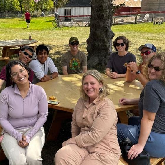 The Harvest Pack team gathered around a picnic table at the sanctuary