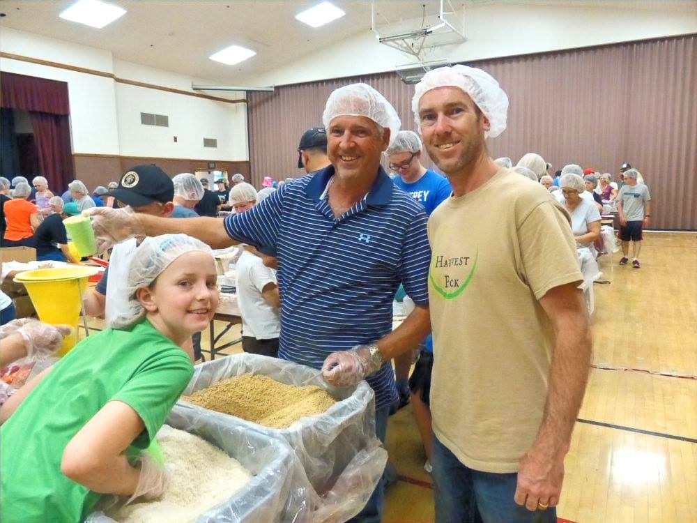 Volunteers packing meals at a school gym event